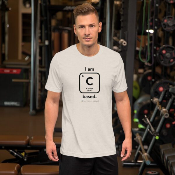 Male model in the gym wearing a dust "I am Carbon (as an element) Based" shirt. Atomic Hands logo on the bottom.