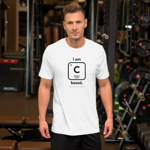 Male model in the gym wearing a white "I am Carbon (as an element) Based" shirt. Atomic Hands logo on the bottom.