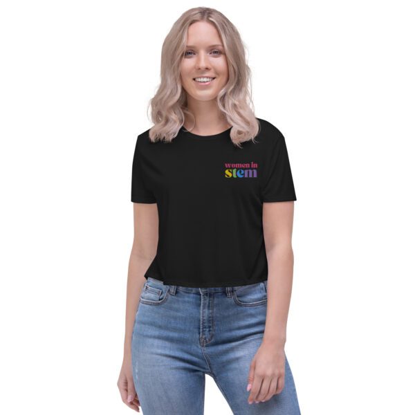 A female model with blond hair wearing a dust crop tee with embroidered "women in stem" and jeans