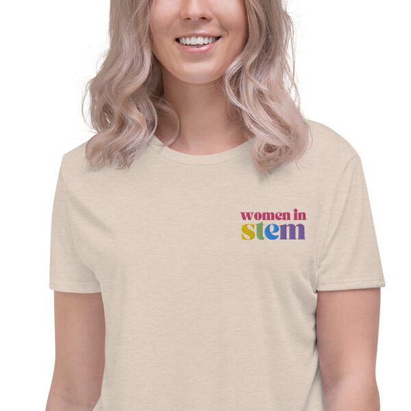 Close up of a female model with blond hair wearing a dust crop tee with embroidered "women in stem"