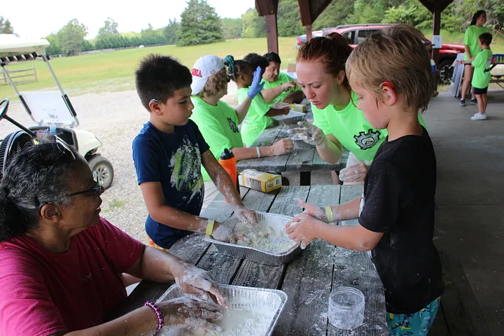 signs of fun camp kids seated at a table